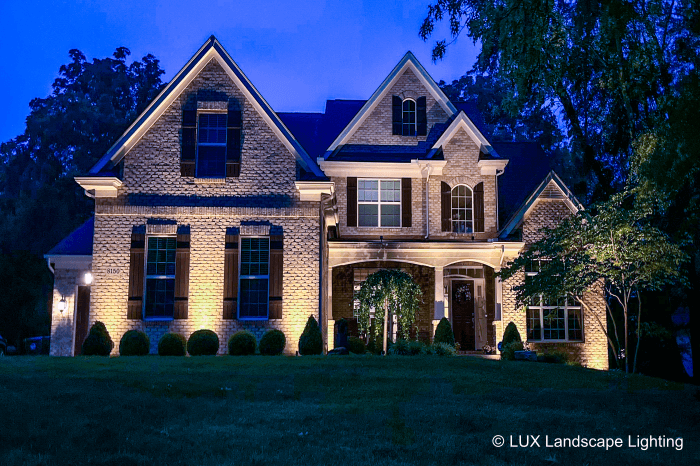 Residential lights shining on a white house. 